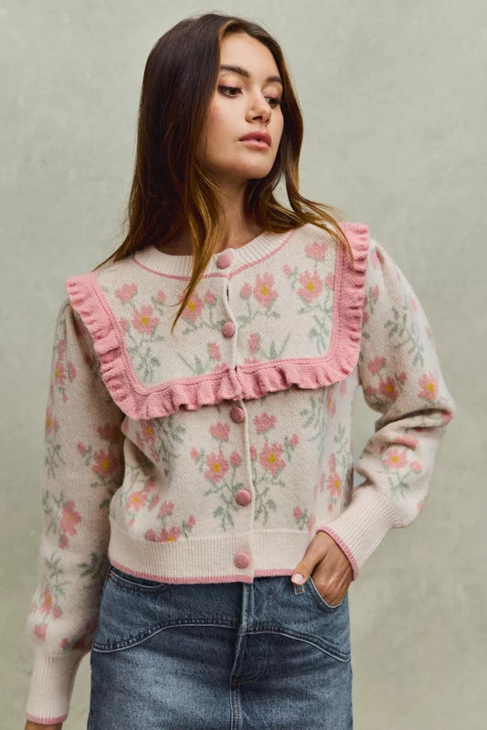 Floral knit cardigan with pink ruffled yoke and covered buttons.