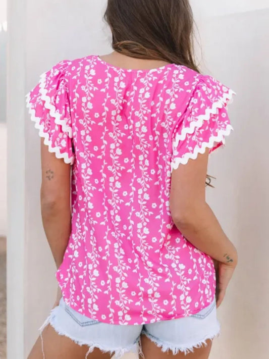 pink floral blouse with scalloped flutter sleeves and vine print