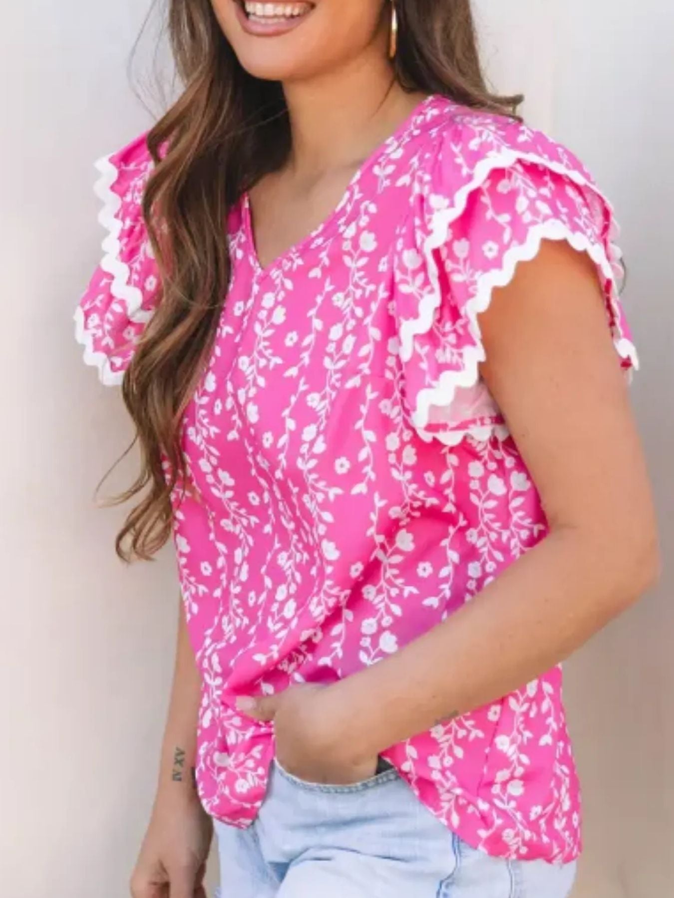 pink floral blouse with scalloped flutter sleeves and vine print