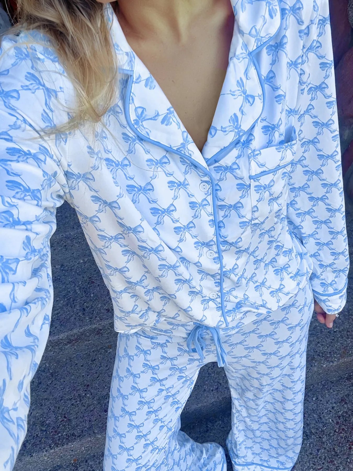 Women’s two-piece pajama set with blue bow print, button-down top, and drawstring pants, cozy and stylish sleepwear.