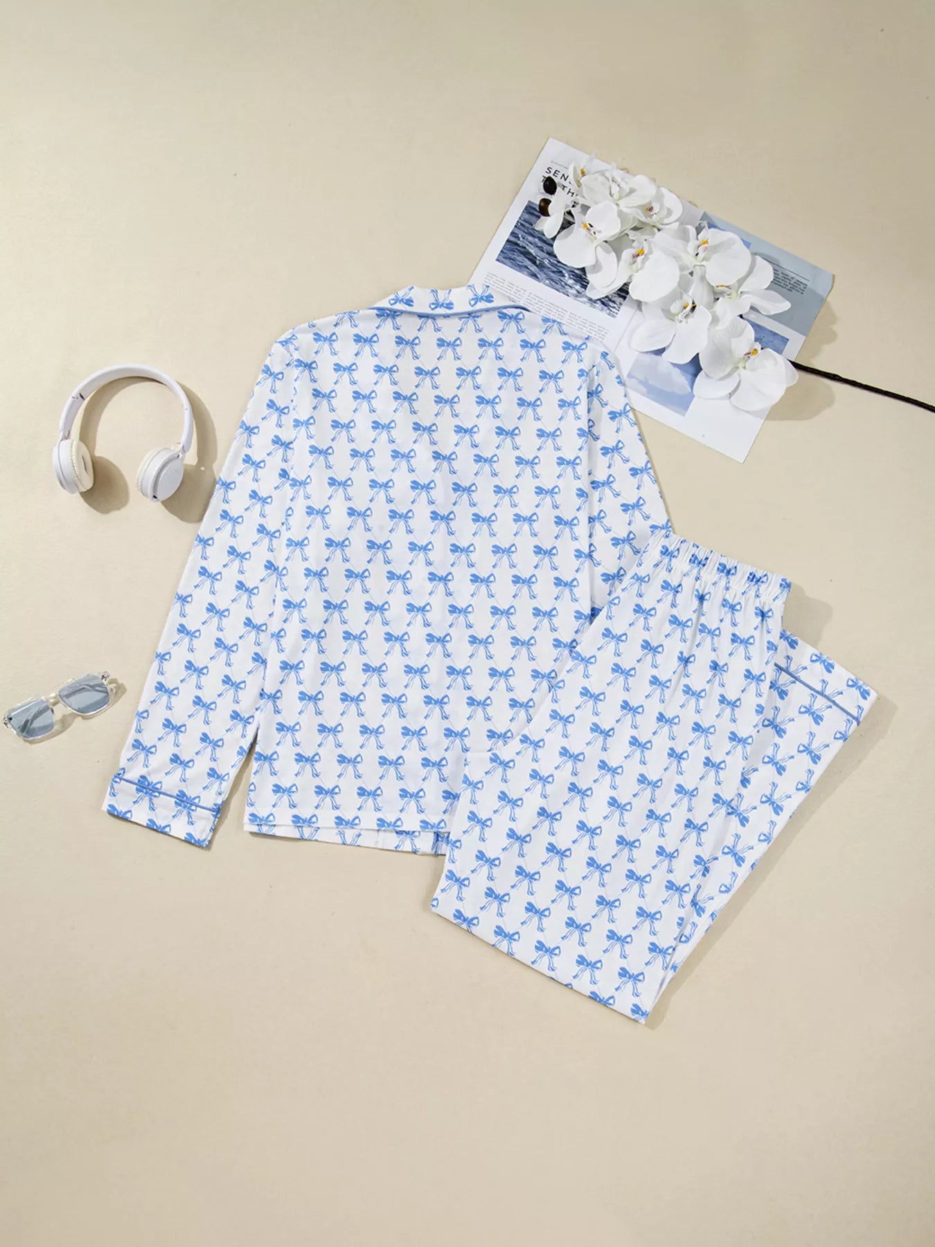 Women’s two-piece pajama set with blue bow print, button-down top, and drawstring pants, cozy and stylish sleepwear.