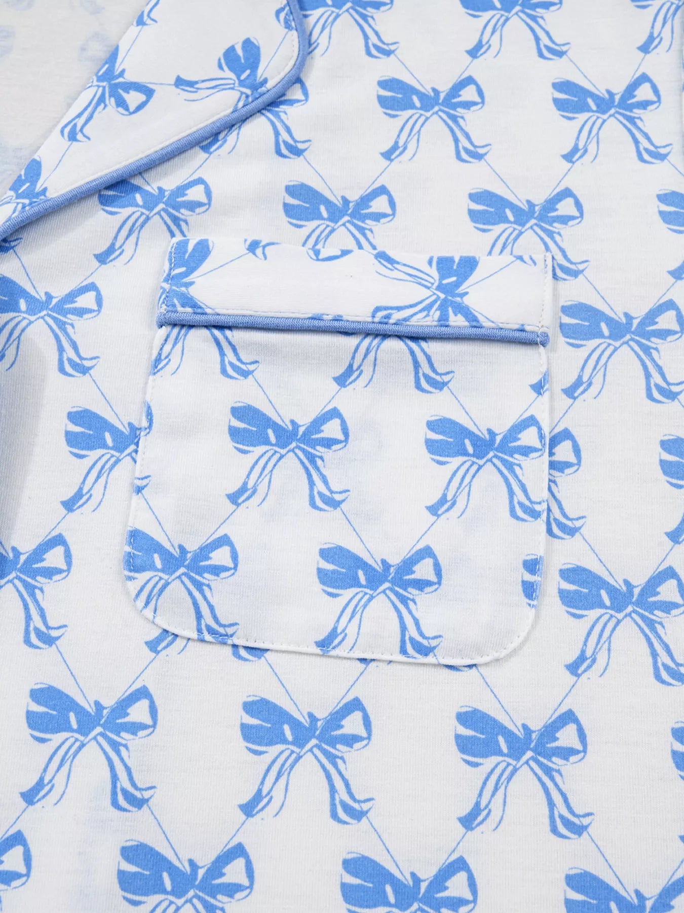 Women’s two-piece pajama set with blue bow print, button-down top, and drawstring pants, cozy and stylish sleepwear.
