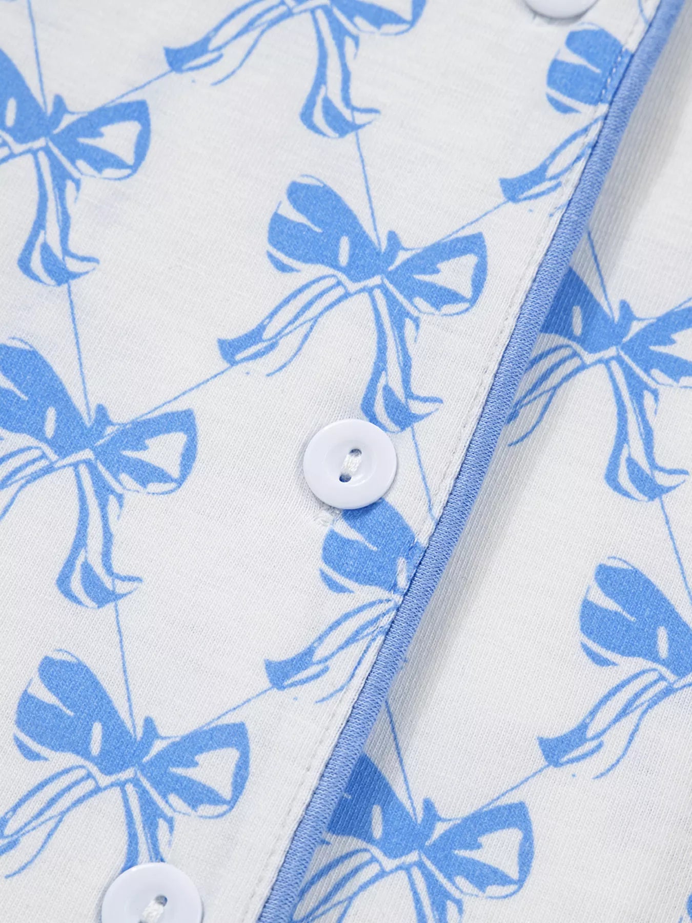 Women’s two-piece pajama set with blue bow print, button-down top, and drawstring pants, cozy and stylish sleepwear.