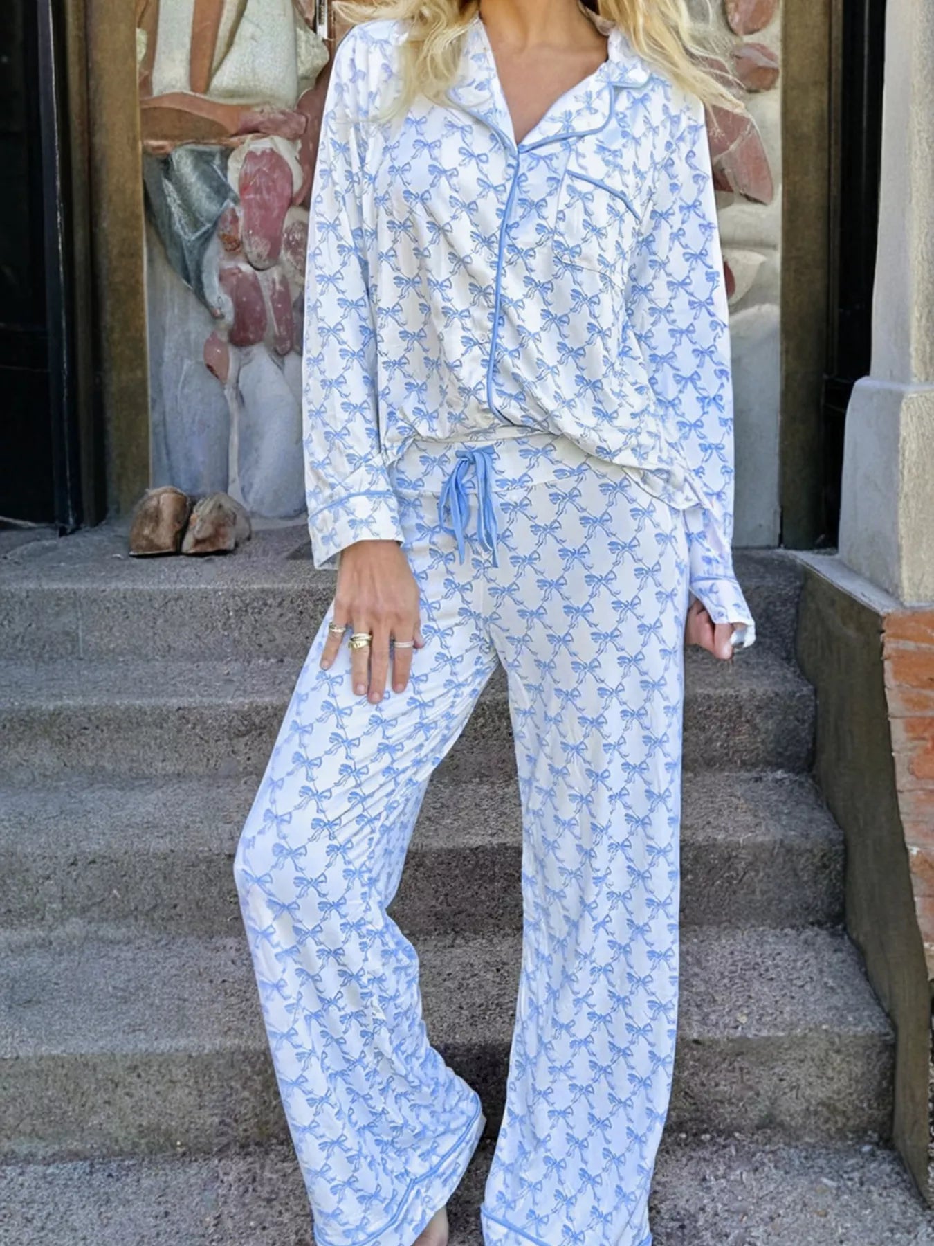 Women’s two-piece pajama set with blue bow print, button-down top, and drawstring pants, cozy and stylish sleepwear.