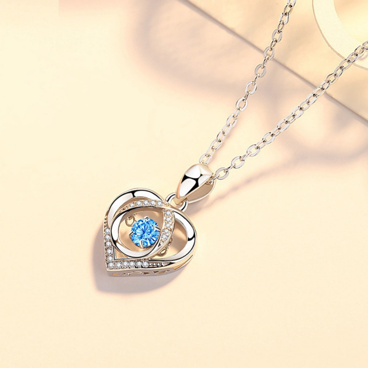 Sterling silver heart pendant necklace with blue gemstone center