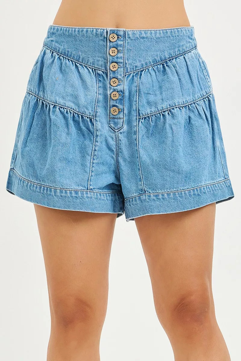 Light blue denim shorts with button-front detail, elastic waistband, shirred panels, and relaxed flowy fit.