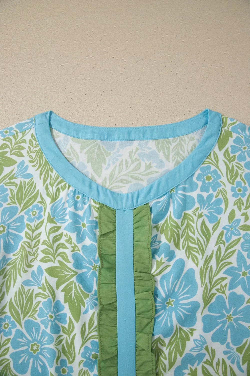 blue floral boho blouse with green ruffle trim and flutter sleeves