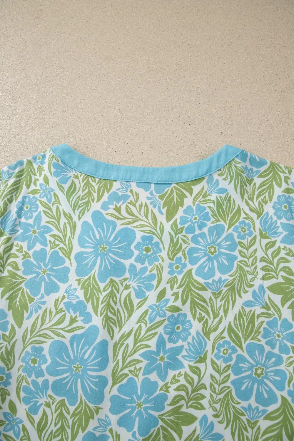 blue floral boho blouse with green ruffle trim and flutter sleeves
