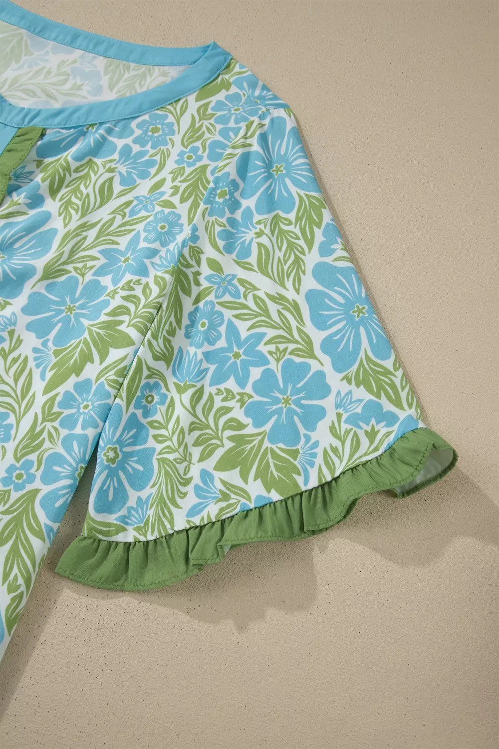 blue floral boho blouse with green ruffle trim and flutter sleeves