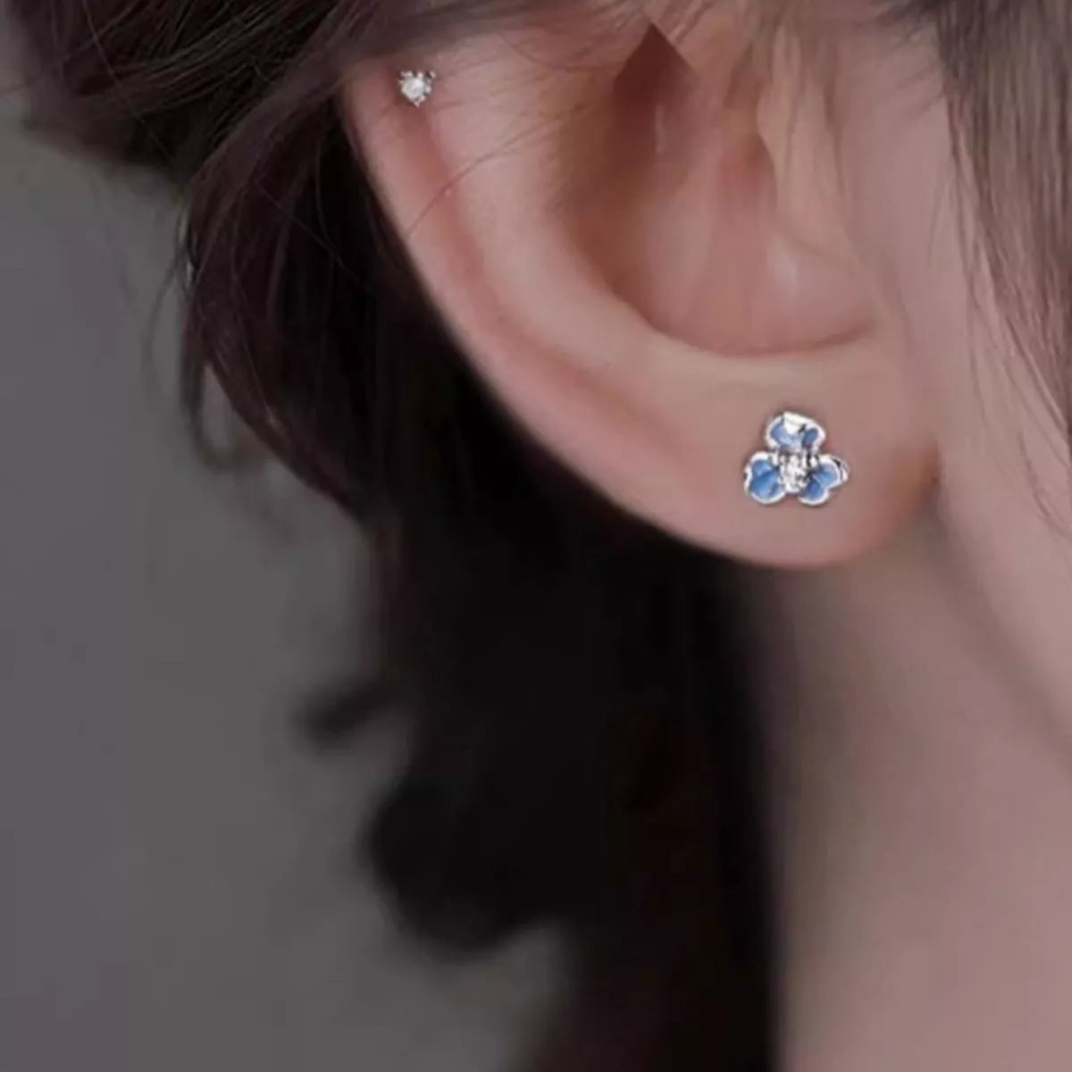 Sterling silver floral stud earrings with blue enamel petals