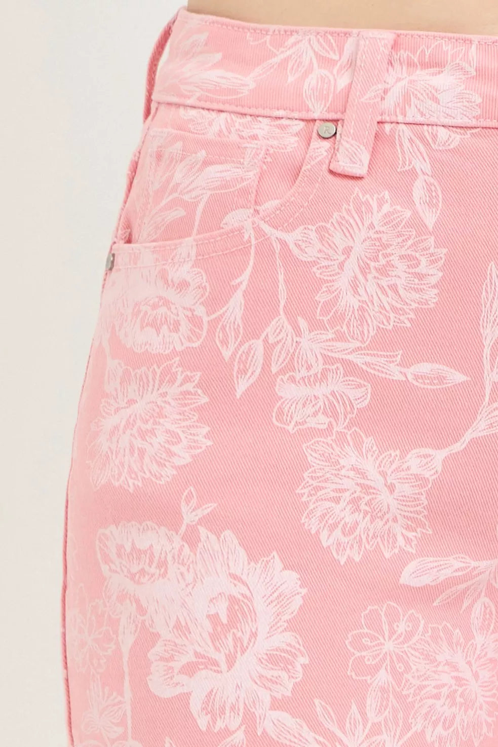Pink high rise shorts with white floral print and frayed hem detail.