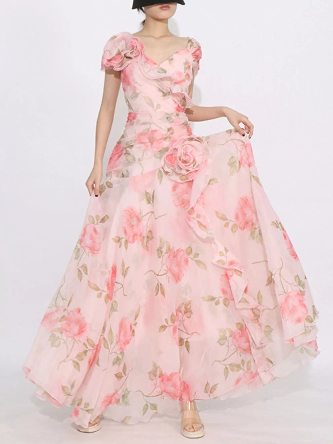 Pink floral tiered gown with ruffled details, puff sleeves, and rose appliqué accents.