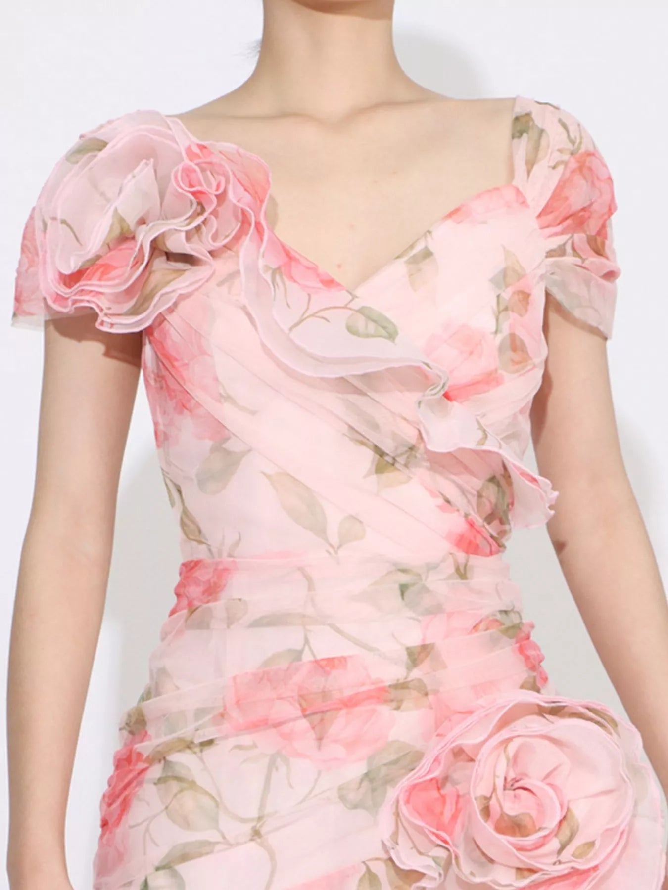 Pink floral tiered gown with ruffled details, puff sleeves, and rose appliqué accents.