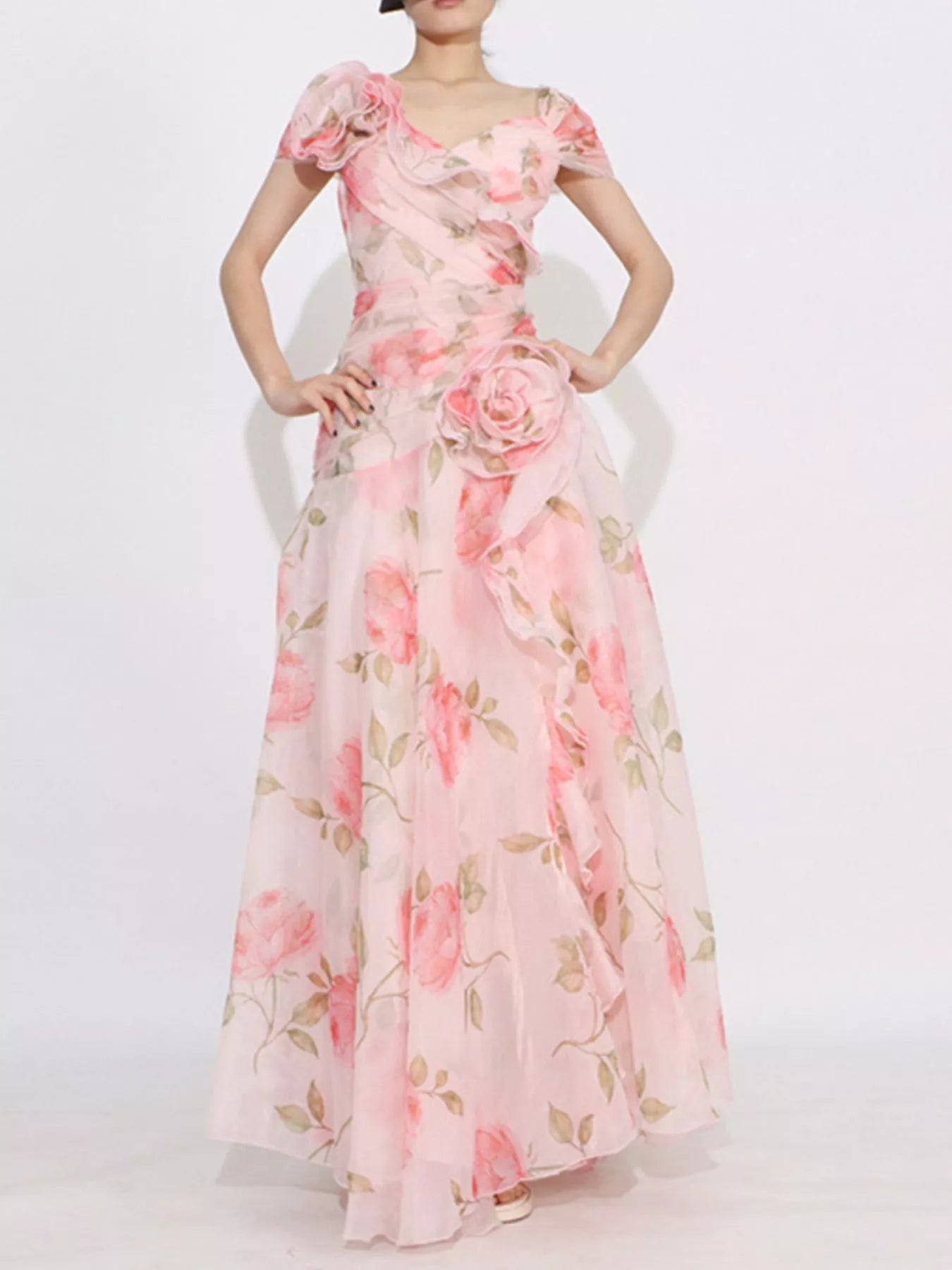 Pink floral tiered gown with ruffled details, puff sleeves, and rose appliqué accents.