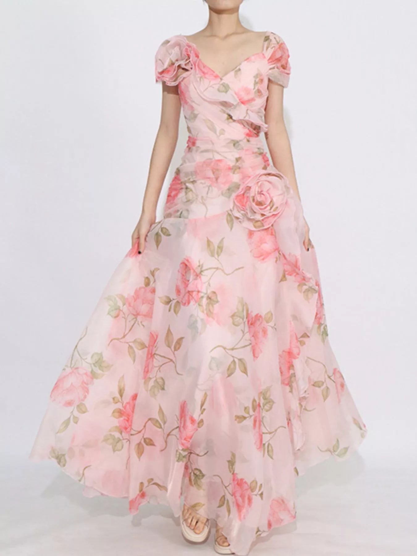 Pink floral tiered gown with ruffled details, puff sleeves, and rose appliqué accents.