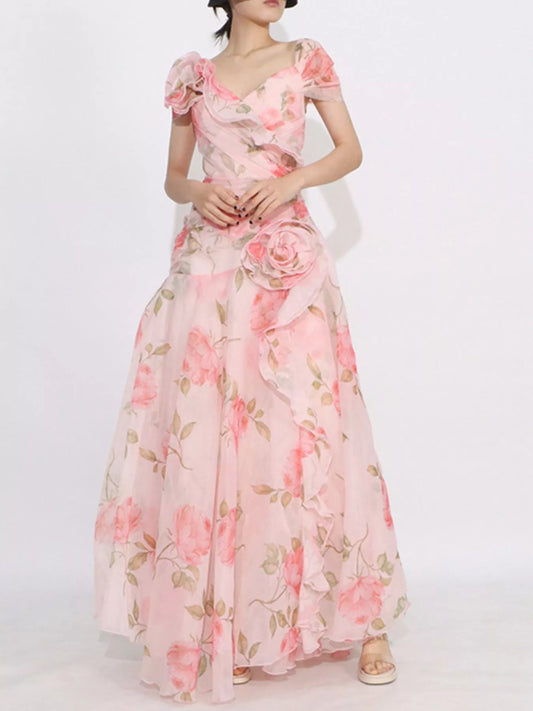 Pink floral tiered gown with ruffled details, puff sleeves, and rose appliqué accents.
