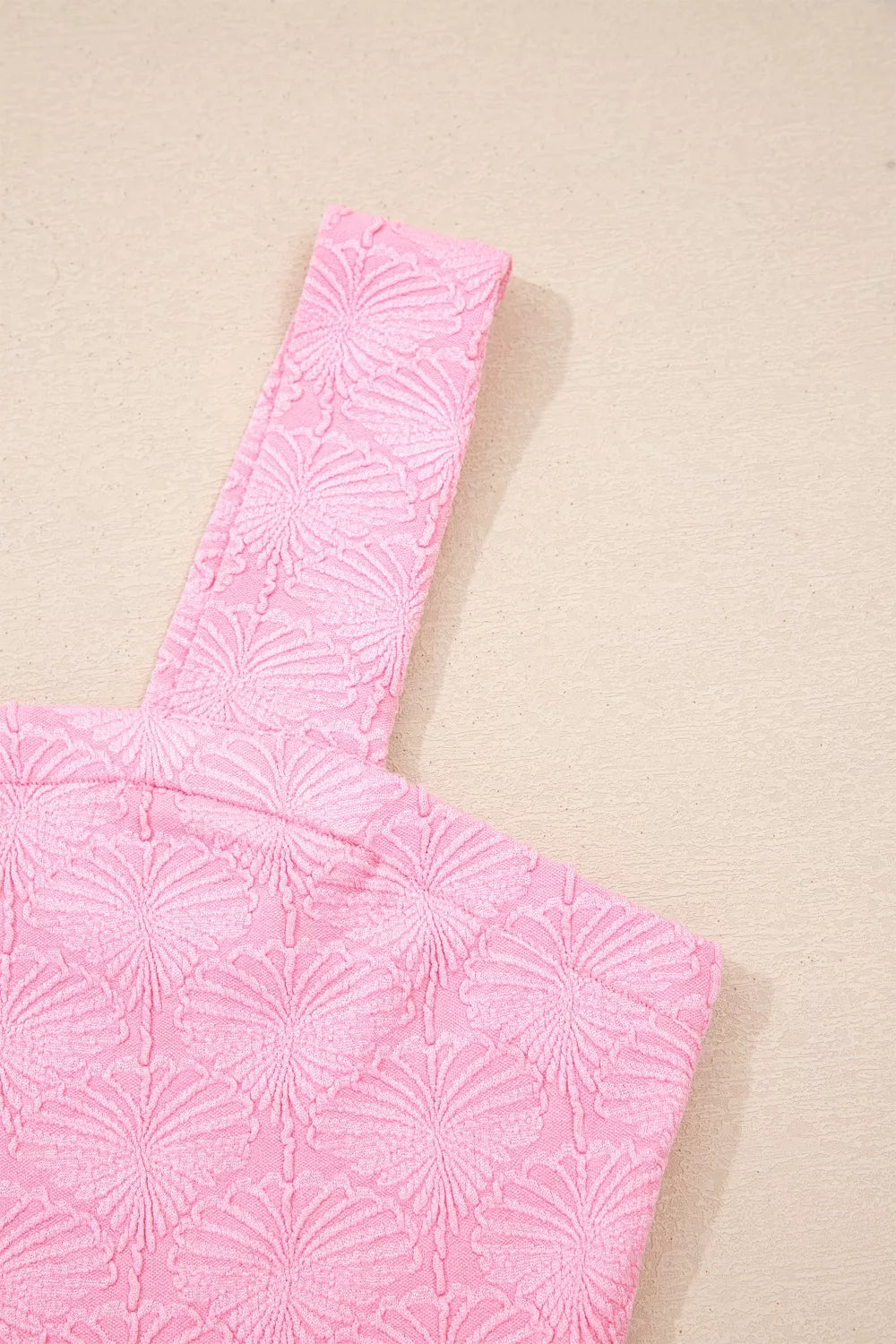 Pink square neck tank top with floral textured fabric, wide straps, and a slightly stretchy fit styled with light denim.