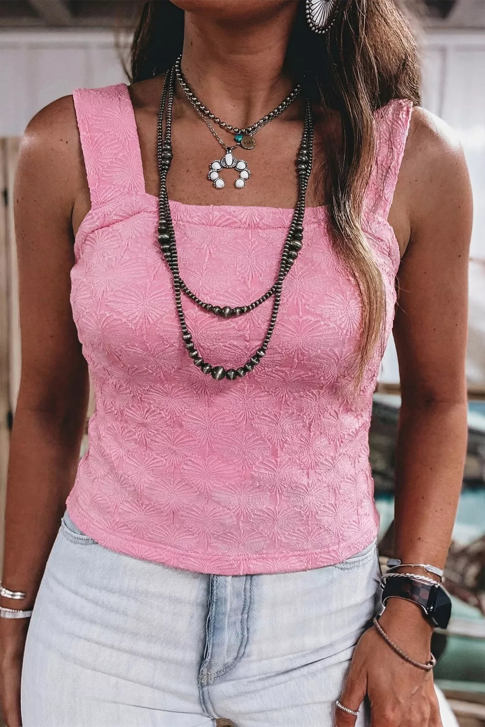 Pink square neck tank top with floral textured fabric, wide straps, and a slightly stretchy fit styled with light denim.