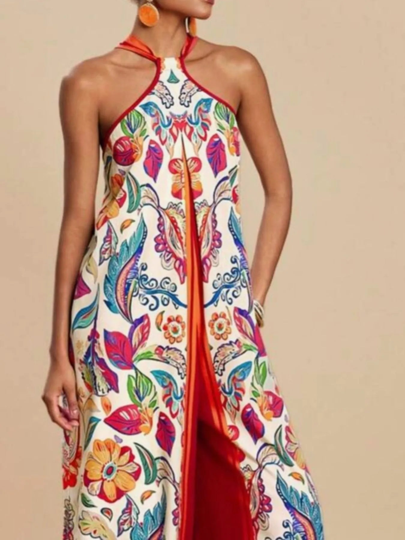 Model wearing red multicolor Boho Breeze Halter Jumpsuit with floral and leaf print, wide-leg design, and halter neckline.