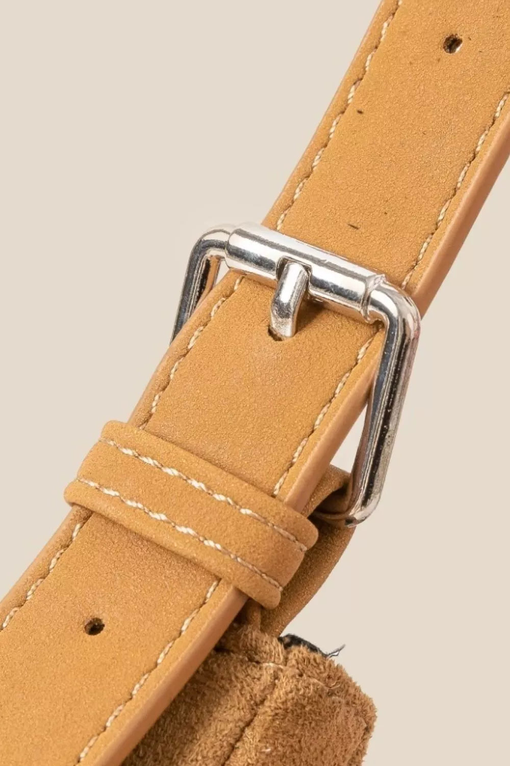 Tan suede crossbody bag with long fringe detailing and boho-inspired design.