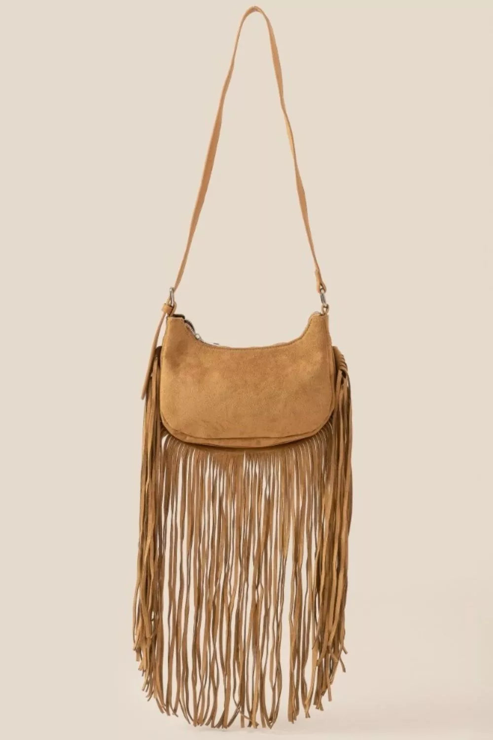 Tan suede crossbody bag with long fringe detailing and boho-inspired design.