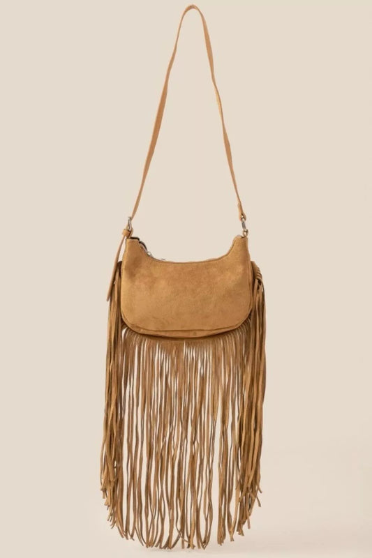Tan suede crossbody bag with long fringe detailing and boho-inspired design.