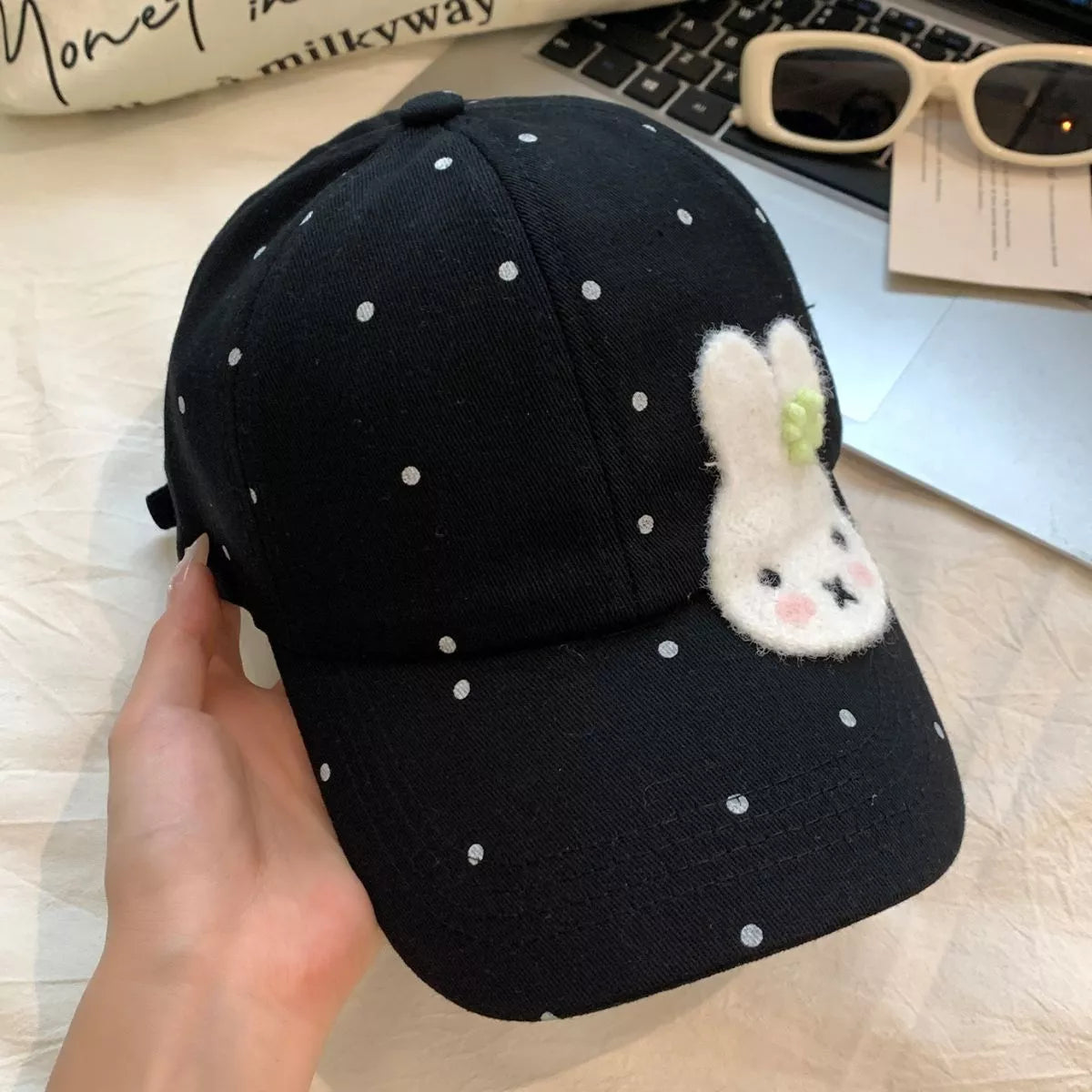 Cotton baseball cap with polka dot print, fuzzy bunny face patch, curved brim, and multiple color options.