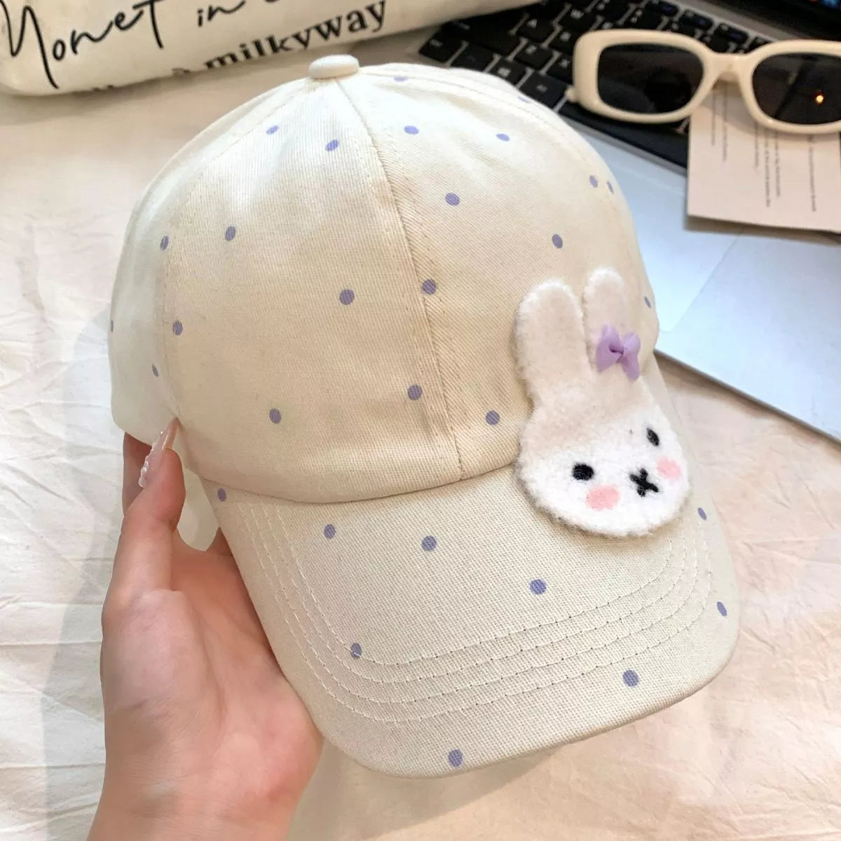 Cotton baseball cap with polka dot print, fuzzy bunny face patch, curved brim, and multiple color options.