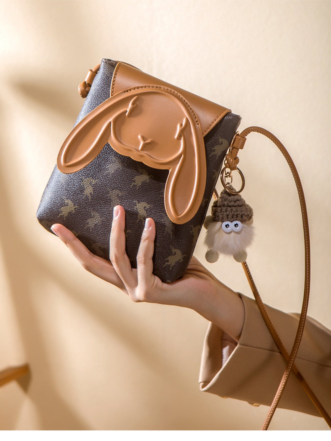 Mini crossbody bag with bunny ear flap design worn with neutral outfit