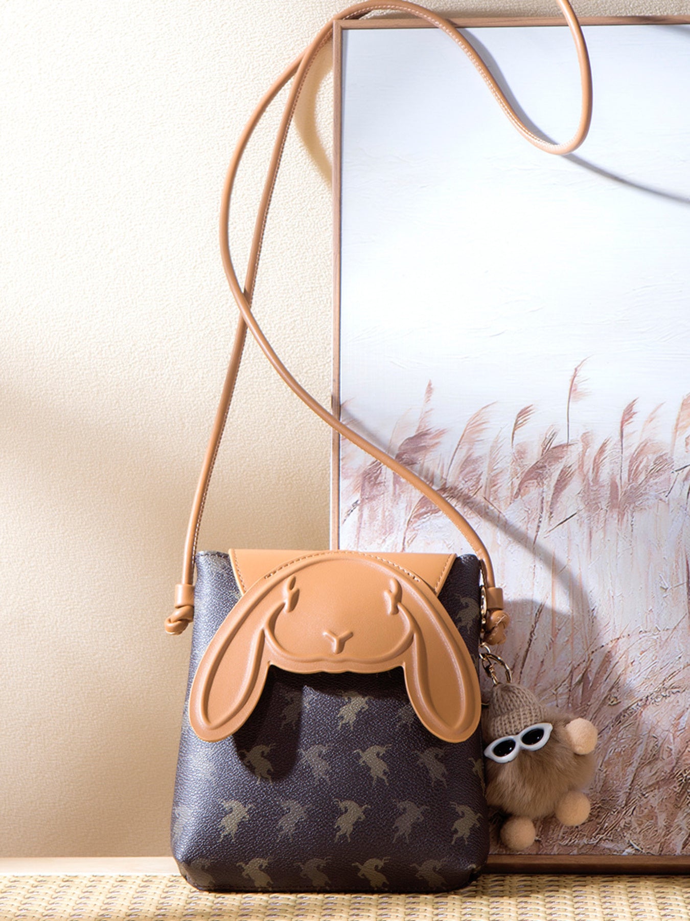 Mini crossbody bag with bunny ear flap design worn with neutral outfit