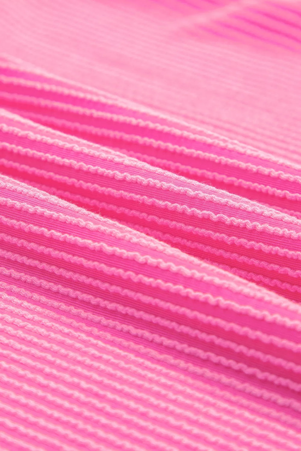 Color block ribbed V-neck tee with pink body, blue shoulders, orange sleeves, seam details, and slightly stretchy fit.