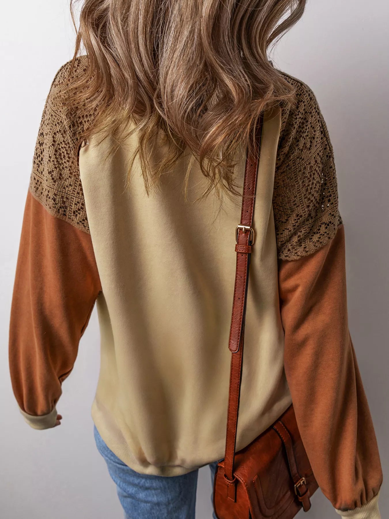 Boho pullover with contrast long sleeves, lace-inspired shoulder panels, ribbed trim, relaxed fit, and slightly stretchy fabric styled with denim.