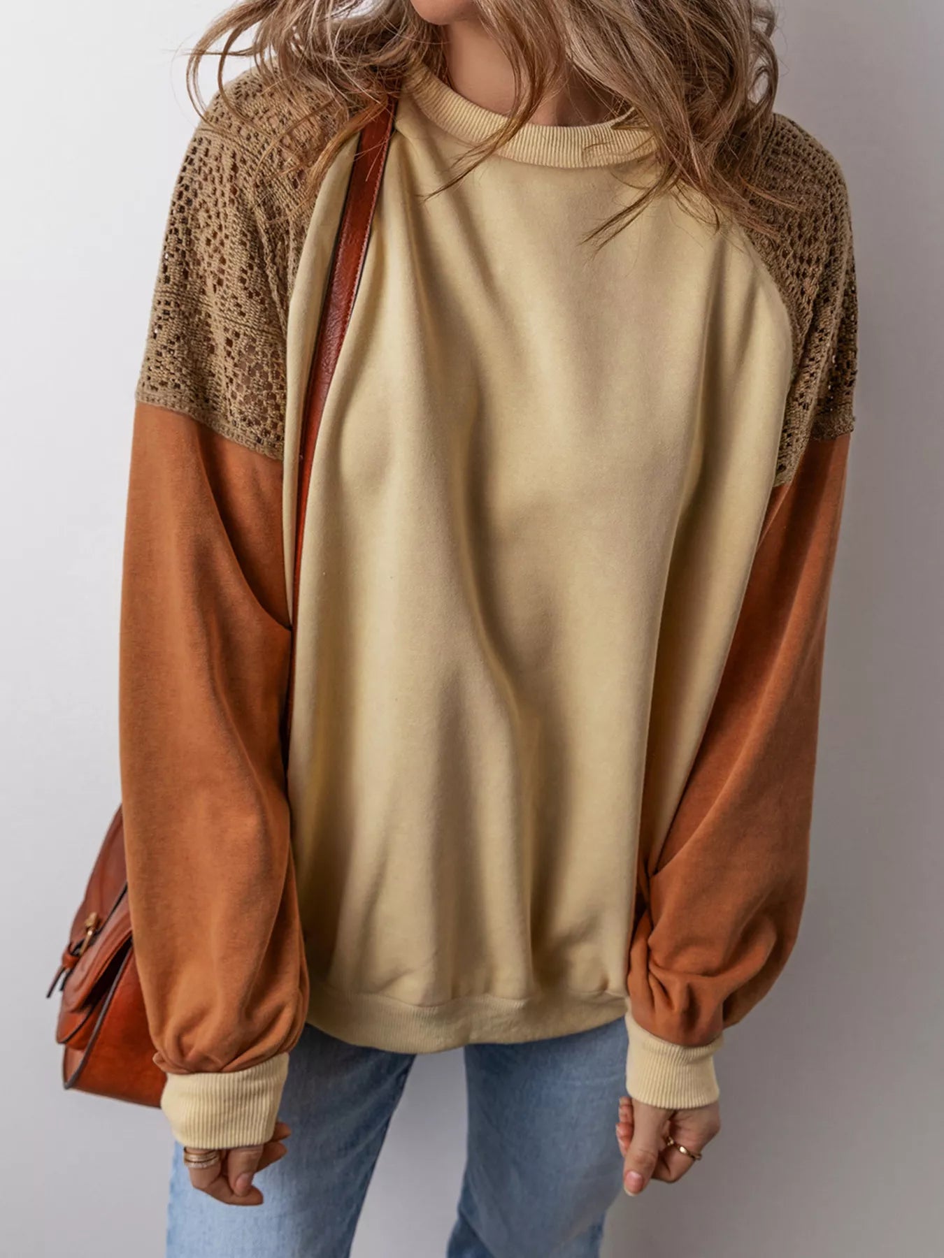 Boho pullover with contrast long sleeves, lace-inspired shoulder panels, ribbed trim, relaxed fit, and slightly stretchy fabric styled with denim.