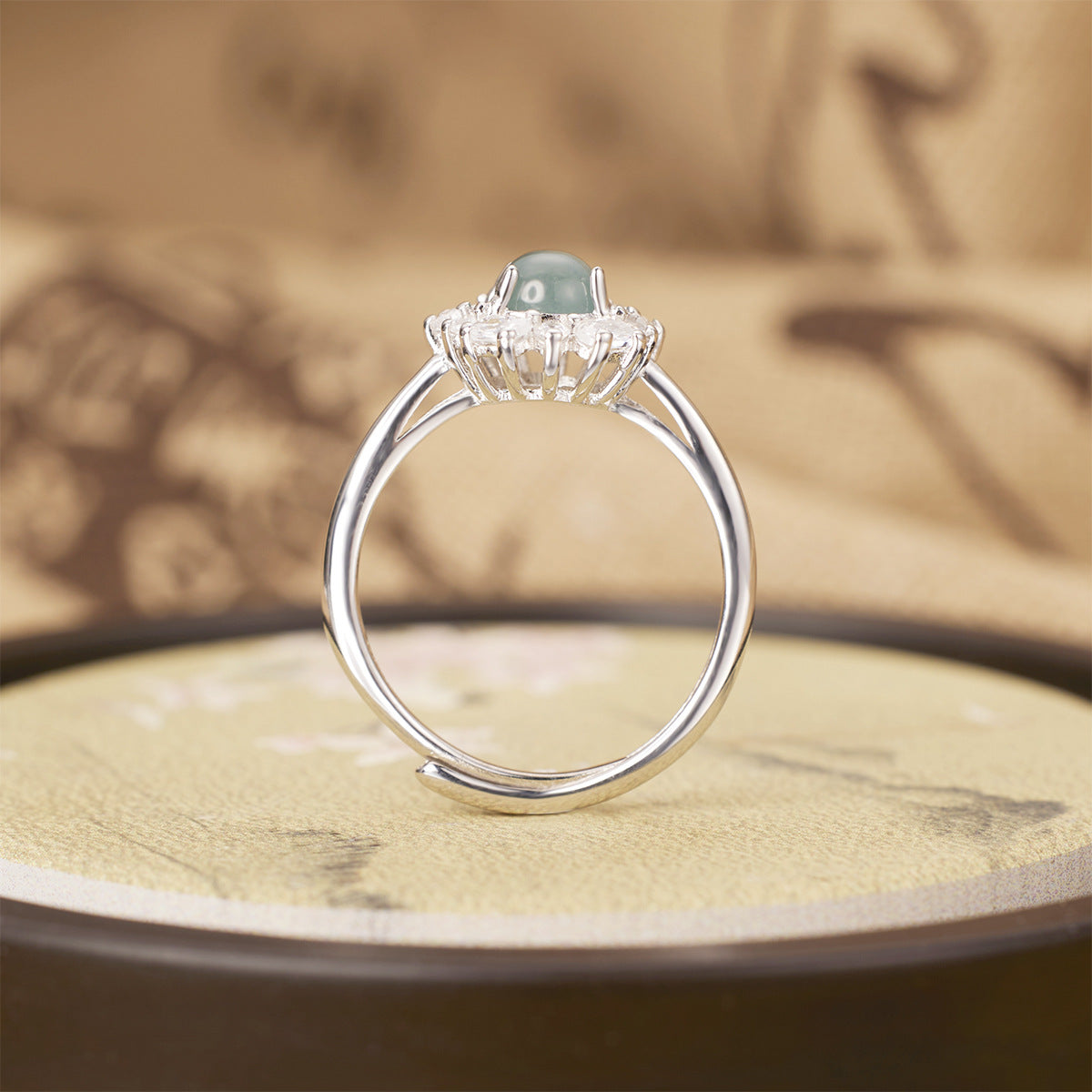 Sterling silver jadeite ring with round green center stone and zircon halo accents