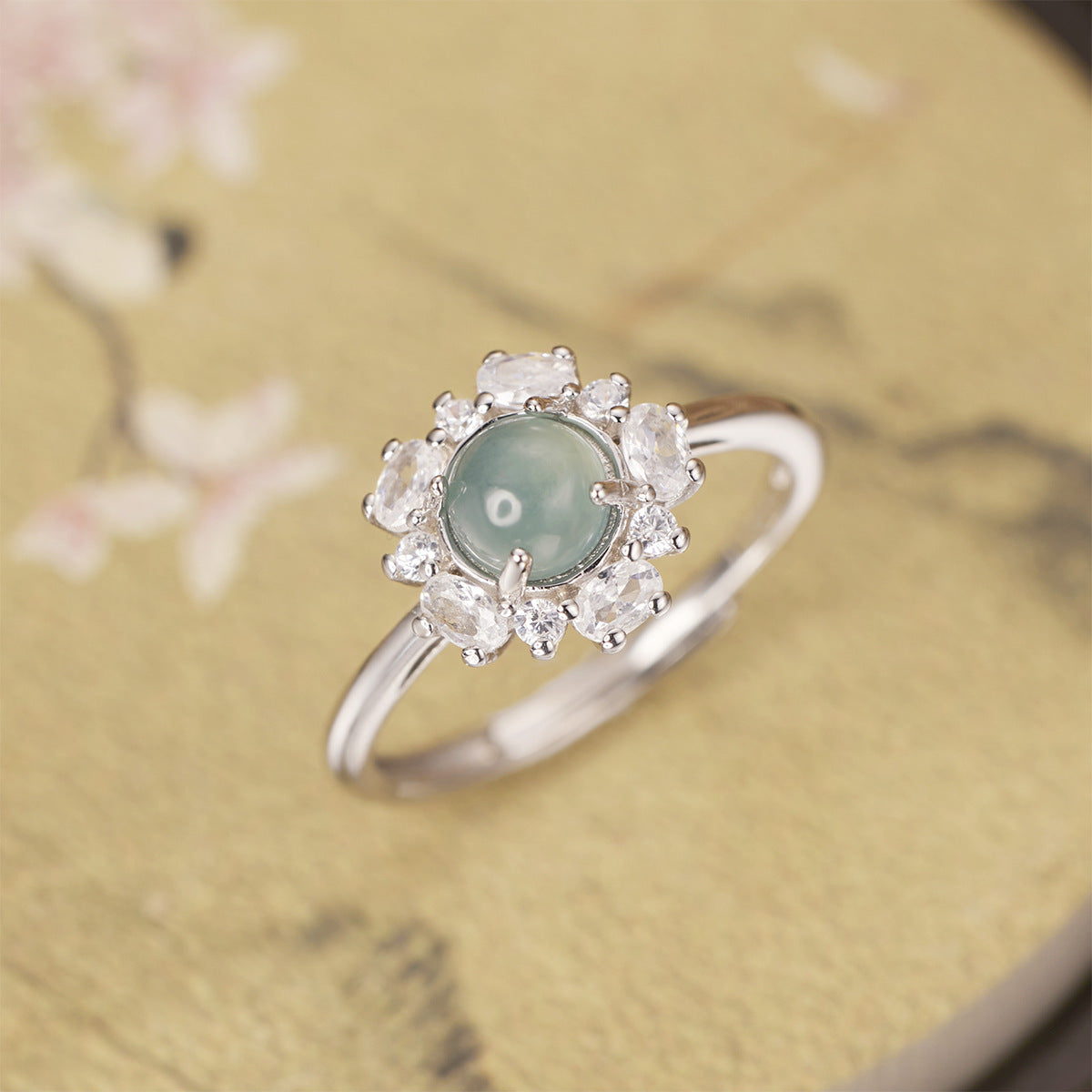 Sterling silver jadeite ring with round green center stone and zircon halo accents