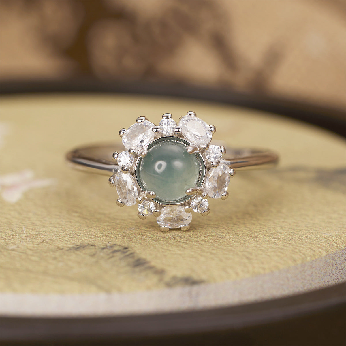 Sterling silver jadeite ring with round green center stone and zircon halo accents