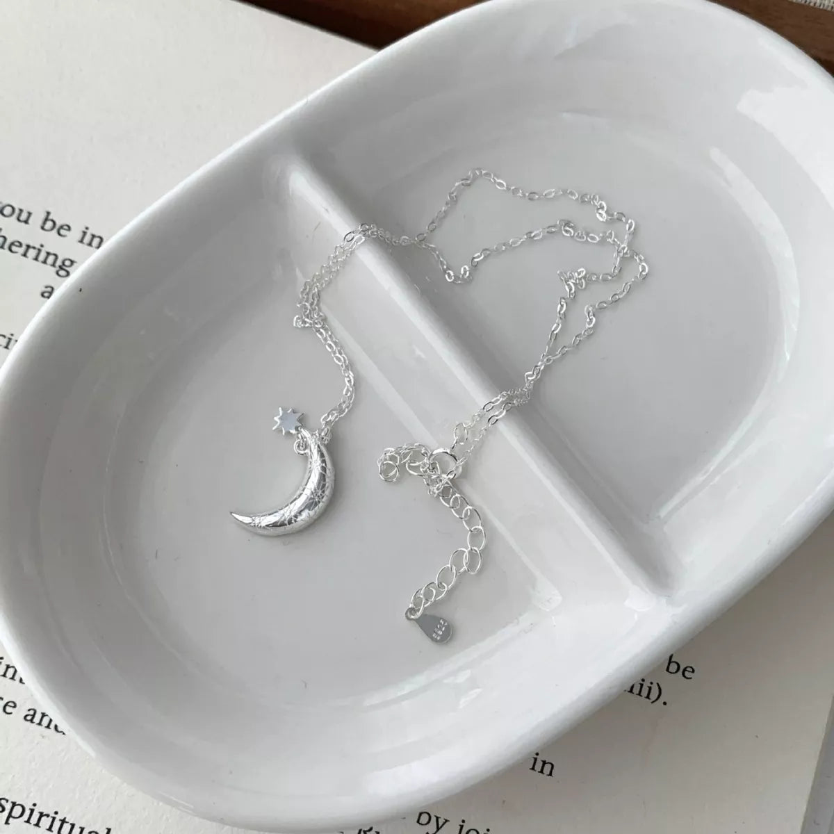 Sterling silver crescent moon pendant necklace with delicate star detail