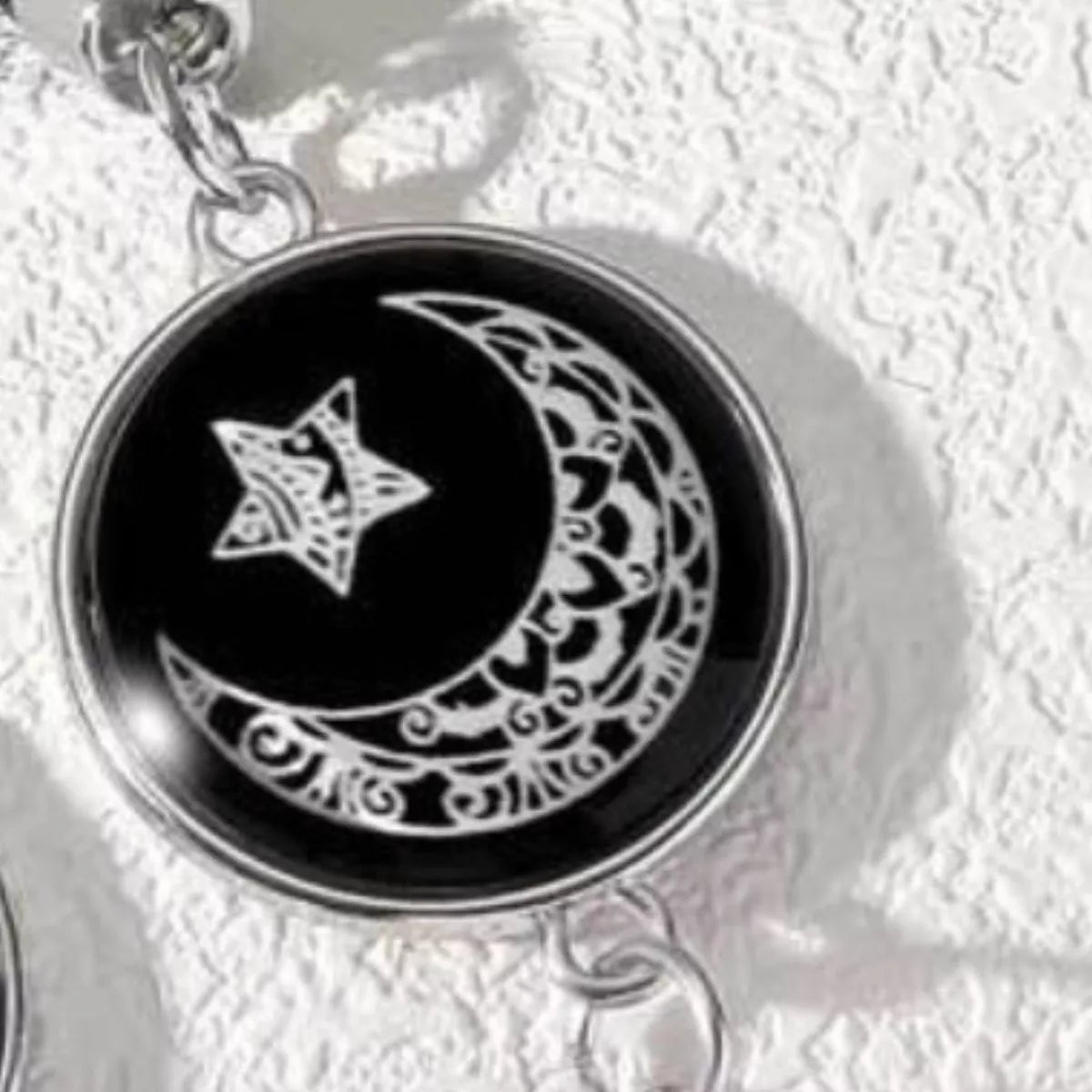 Two-piece glow-in-the-dark bracelet set with sun and moon charms on black braided rope bands