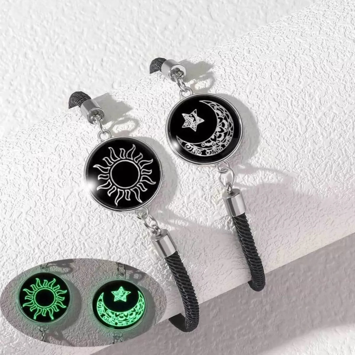 Two-piece glow-in-the-dark bracelet set with sun and moon charms on black braided rope bands