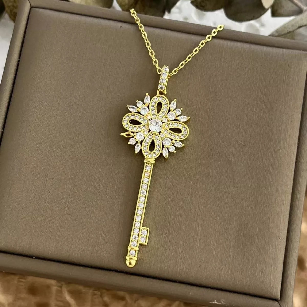 Gold key necklace with sparkling zircon details and ornate design