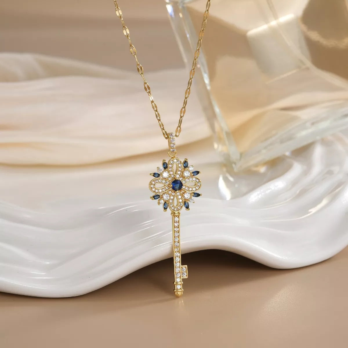 Gold key necklace with sparkling zircon details and ornate design