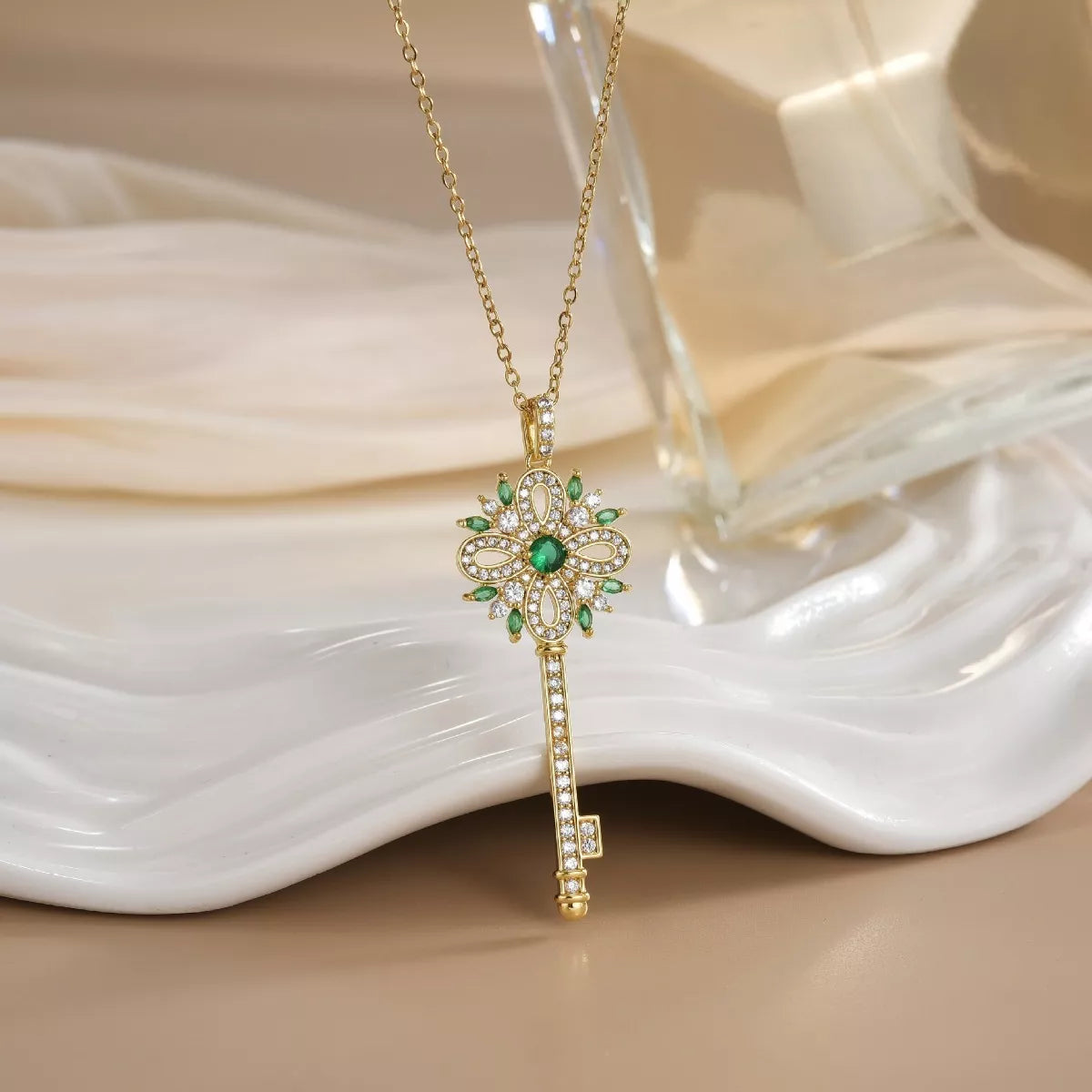 Gold key necklace with sparkling zircon details and ornate design