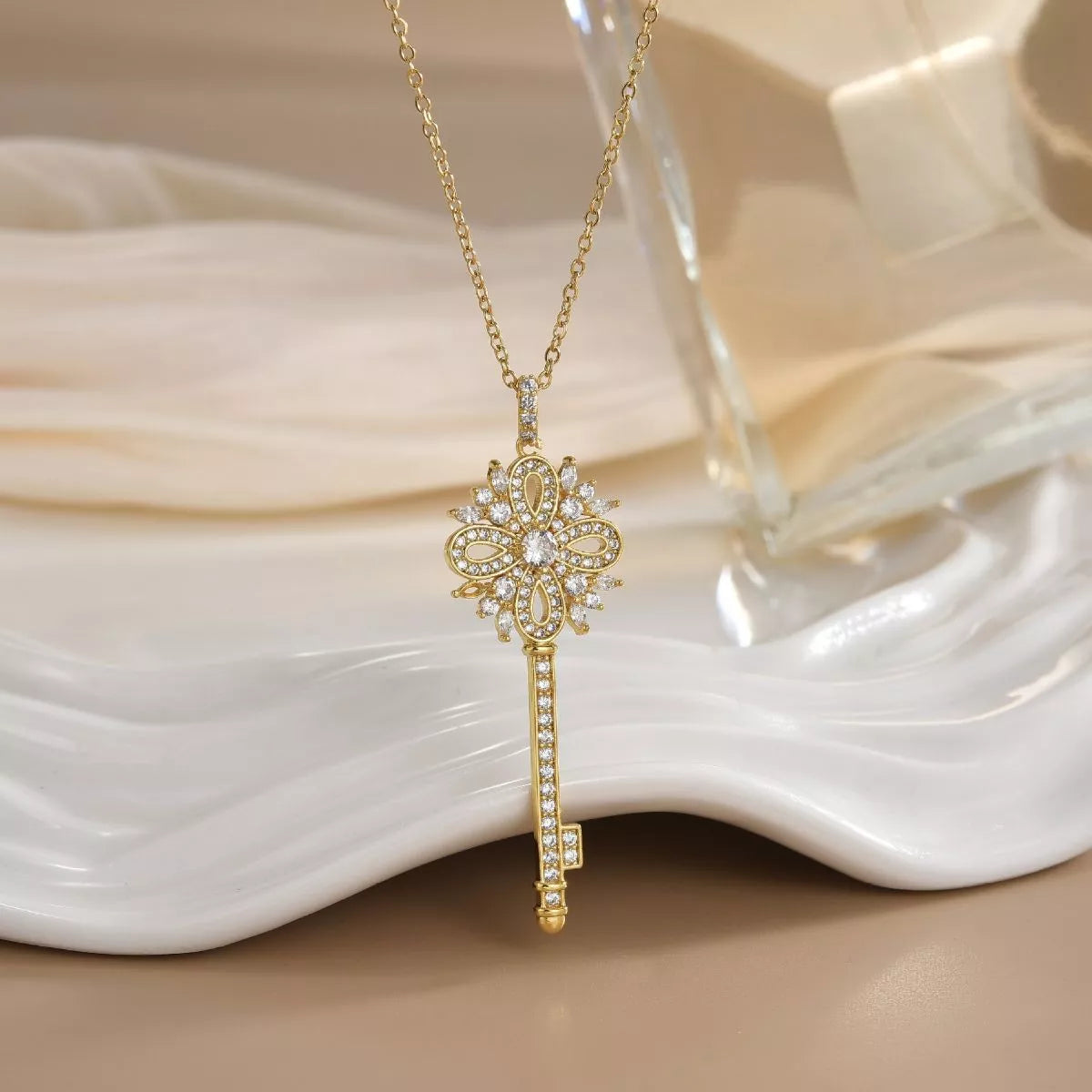 Gold key necklace with sparkling zircon details and ornate design