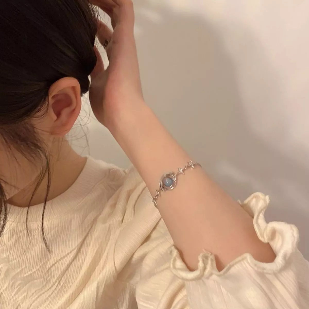 Platinum-plated sterling silver bracelet with celestial star details and a luminous glass stone centerpiece