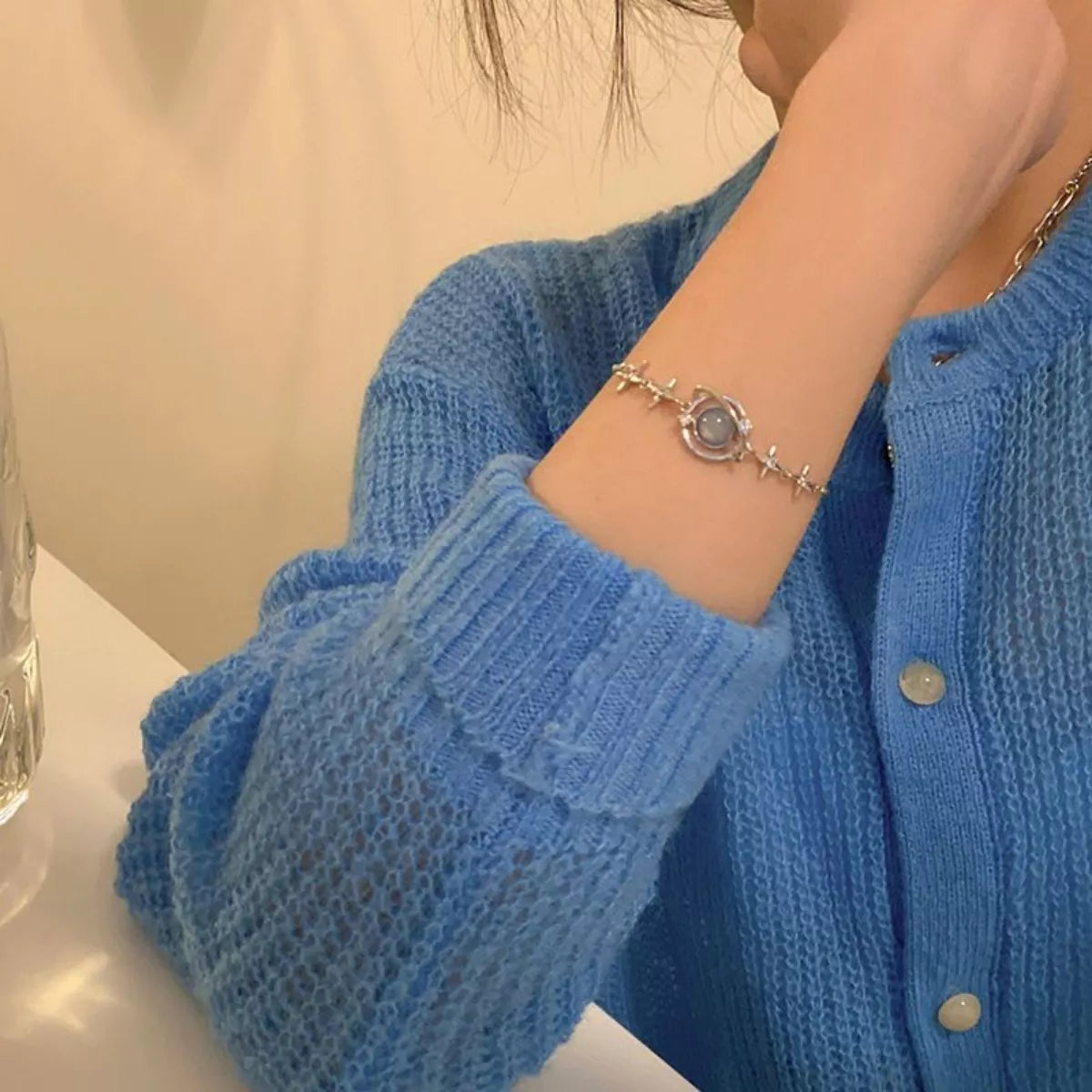 Platinum-plated sterling silver bracelet with celestial star details and a luminous glass stone centerpiece