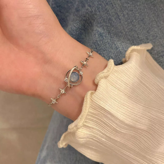 Platinum-plated sterling silver bracelet with celestial star details and a luminous glass stone centerpiece