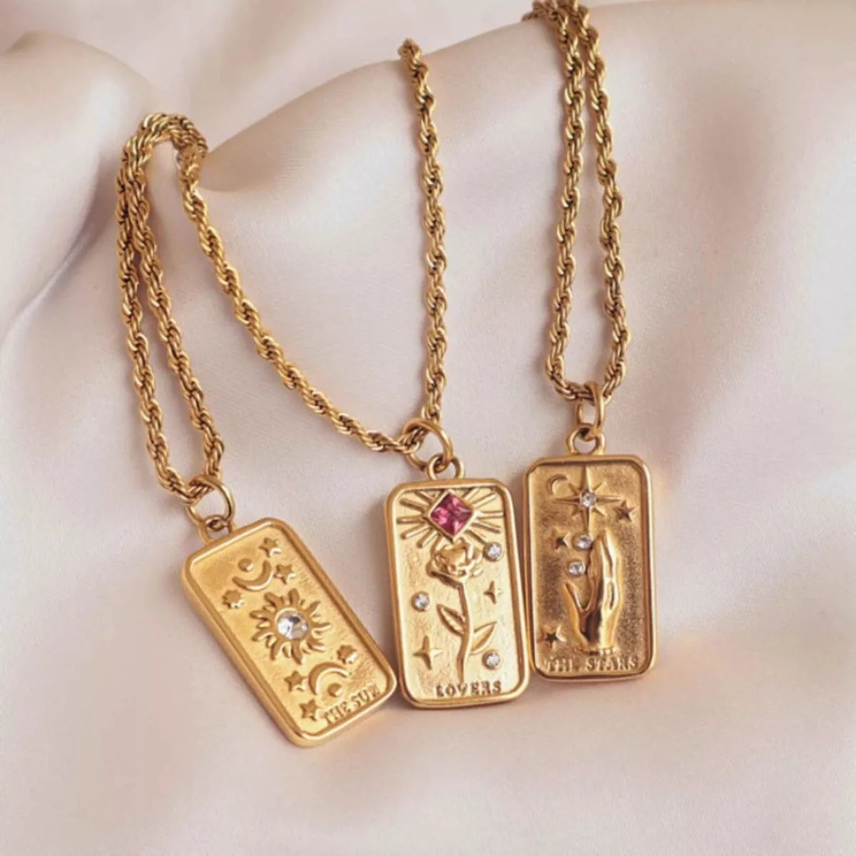 18K gold-plated tarot card necklace featuring the sun, the stars, and lovers tarot card.