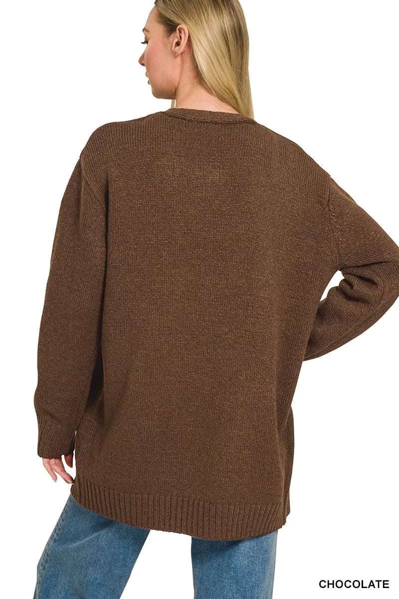 Open-front knit cardigan with front pockets, ribbed trim, long sleeves, and a relaxed slightly stretchy fit styled with jeans.