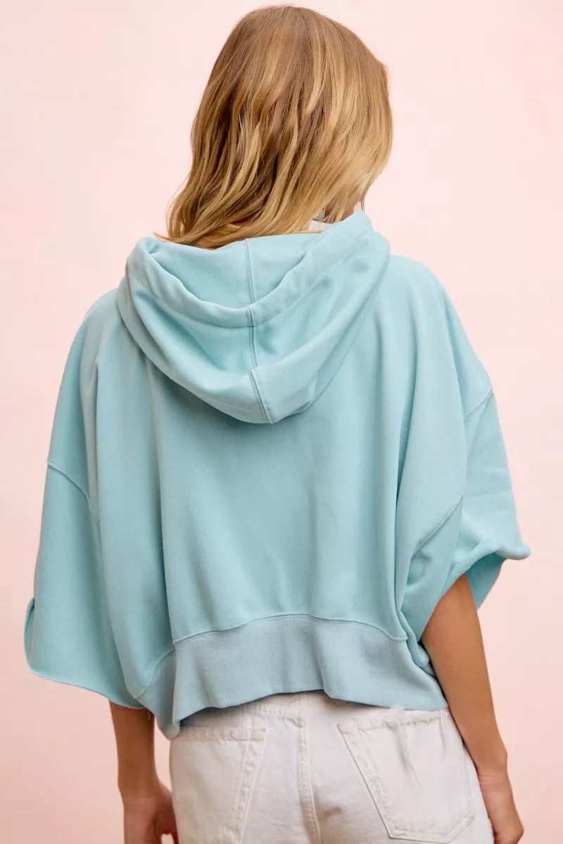 Short sleeve drawstring hoodie in soft washed terry fabric with a relaxed cropped fit and oversized cream drawstrings.