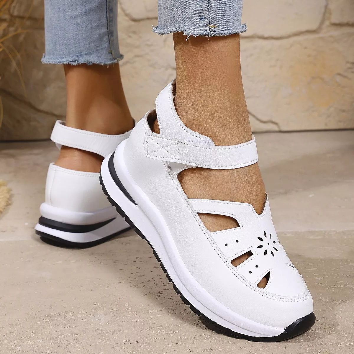 White cutout Mary Jane shoes with adjustable ankle strap, low heel, PU leather material, rubber sole, and casual everyday styling.